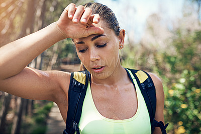 Buy stock photo Cropped shot of an attractive young female athlete looking tired during her morning run