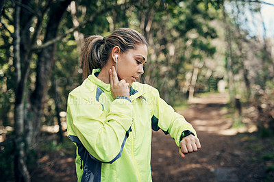 Buy stock photo Cropped shot of an attractive young female athlete tracking her pulse while out for a morning run