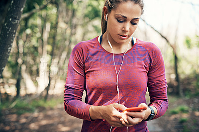 Buy stock photo Cropped shot of an attractive young female athlete listening to music while out for a morning run