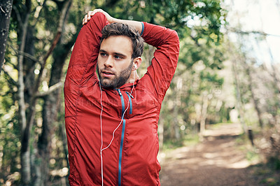 Buy stock photo Cropped shot of a handsome young male athlete stretching before beginning his morning run