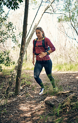 Buy stock photo Full length shot of an attractive young female athlete listening to music while out for a morning run
