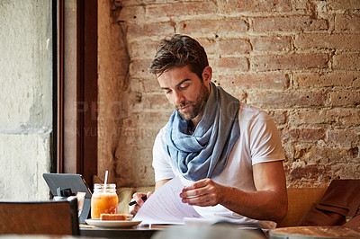 Buy stock photo Cropped shot of a young man doing freelance work in a cafe