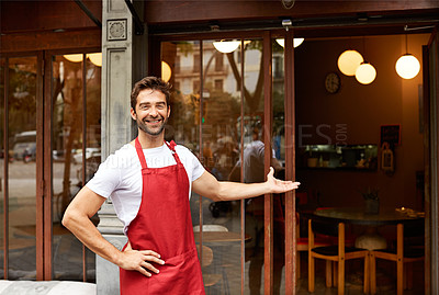 Buy stock photo Shot of a young man standing in front of his coffee shop