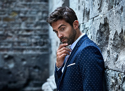 Buy stock photo Cropped shot of a handsome young businessman looking thoughtful while standing in an urban alleyway