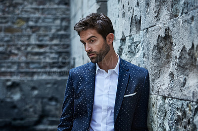 Buy stock photo Cropped shot of a handsome young businessman looking thoughtful while standing in an urban alleyway
