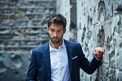 Buy stock photo Cropped shot of a handsome young businessman looking thoughtful while standing in an urban alleyway