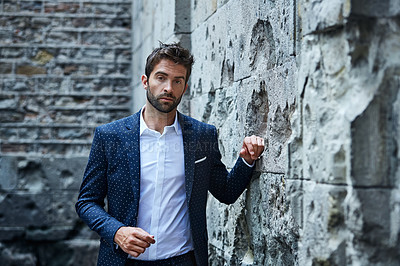 Buy stock photo Cropped portrait of a handsome young businessman standing in an urban alleyway