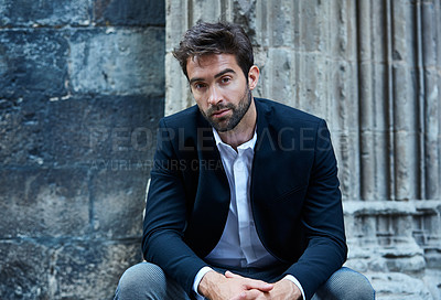 Buy stock photo Cropped portrait of a handsome young businessman sitting in an urban alleyway