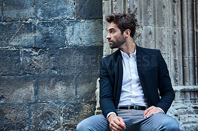 Buy stock photo Cropped shot of a handsome young businessman sitting in an urban alleyway