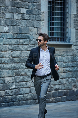 Buy stock photo Cropped shot of a handsome young businessman running through an urban alleyway