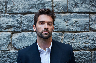 Buy stock photo Cropped portrait of a handsome young businessman standing against a brick wall in an urban alleyway