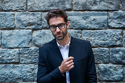 Buy stock photo Cropped portrait of a handsome young businessman standing against a brick wall in an urban alleyway