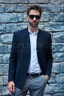 Buy stock photo Cropped portrait of a handsome young businessman standing against a brick wall in an urban alleyway