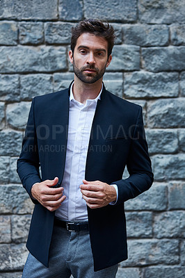Buy stock photo Cropped portrait of a handsome young businessman standing against a brick wall in an urban alleyway