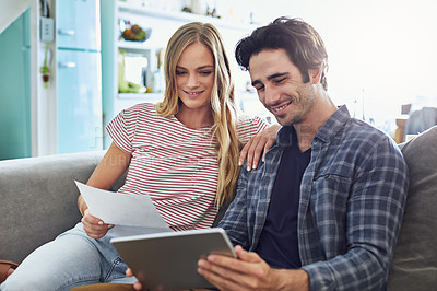 Buy stock photo Cropped shot of a young attractive couple planning their home budget together on the sofa in the living room at home