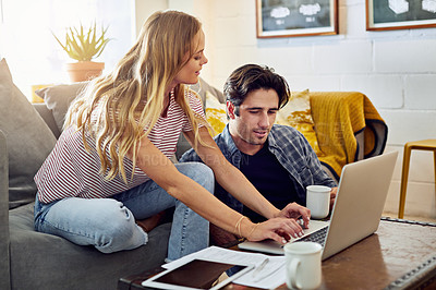 Buy stock photo Cropped shot of a young attractive couple planning their home budget together on the sofa in the living room at home