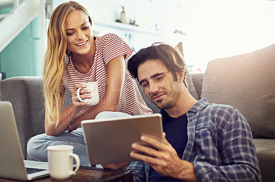 Buy stock photo Cropped shot of a young couple using wireless technology at home