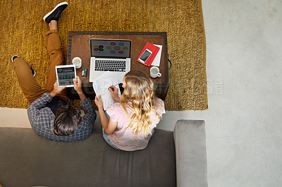 Buy stock photo High angle shot of an unrecognizable couple planning their home budget together on the sofa in the living room at home