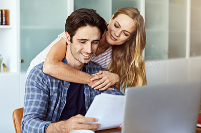 Buy stock photo Shot of a focused young couple doing paperwork together while being seated next to a table at home
