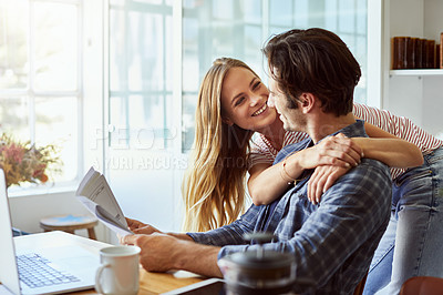 Buy stock photo Shot of a focused young couple doing paperwork together while being seated next to a table at home
