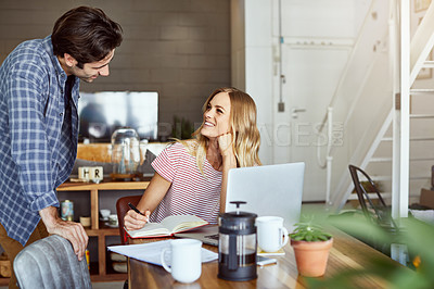 Buy stock photo Shot of a focused young couple doing paperwork together while being seated next to a table at home