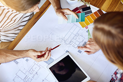 Buy stock photo High angle shot of a focused young couple drawing plans and choosing colors for the renovation of their house