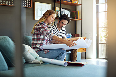 Buy stock photo Shot of a focused young couple drawing plans and choosing colors for the renovation of their house