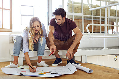 Buy stock photo Shot of a focused young couple drawing plans and choosing colors for the renovation of their house
