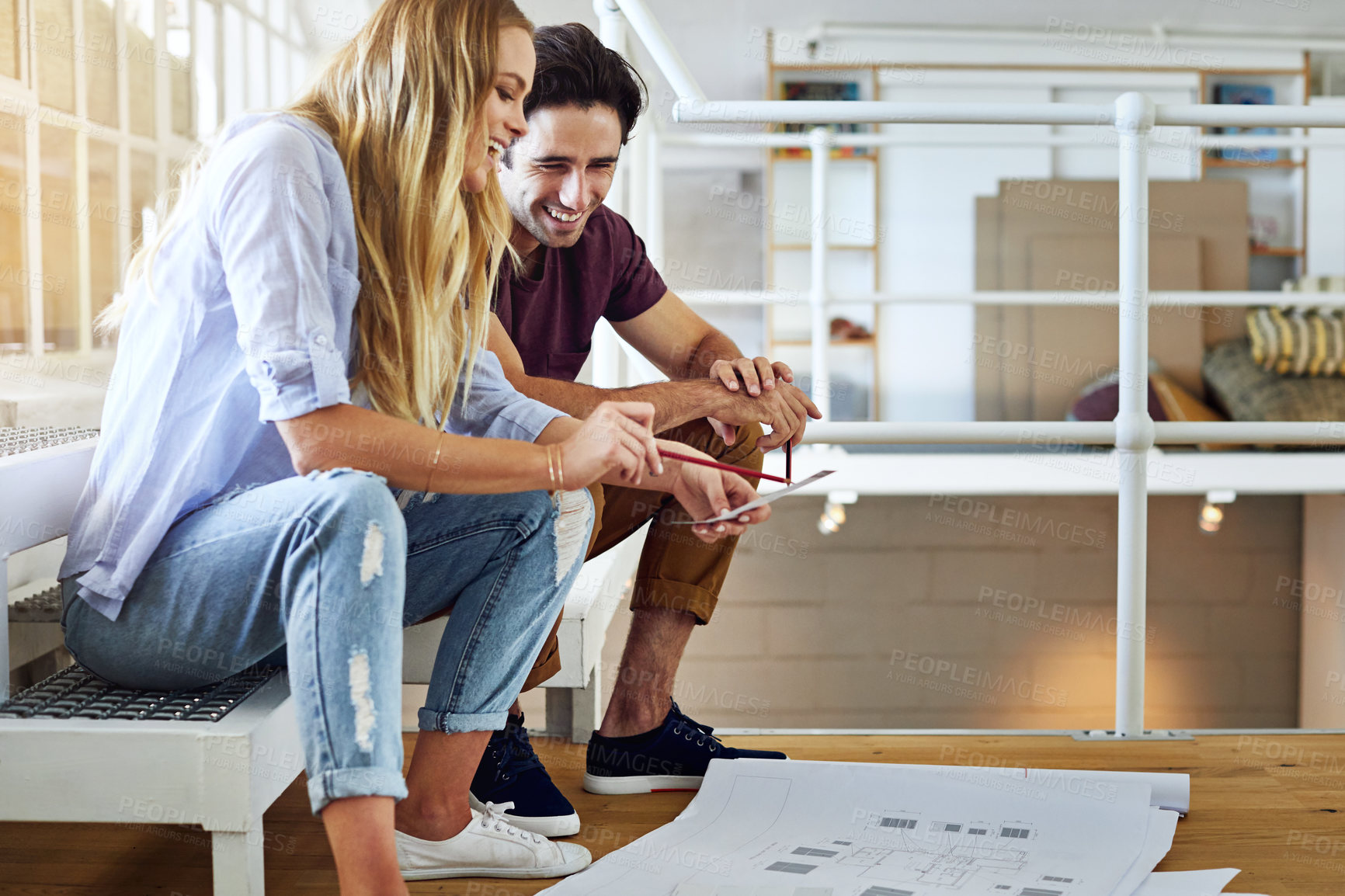 Buy stock photo Shot of a focused young couple drawing plans and choosing colors for the renovation of their house