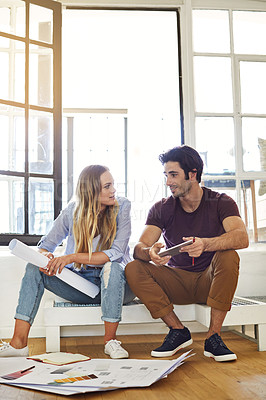 Buy stock photo Shot of a focused young couple drawing plans and choosing colors for the renovation of their house