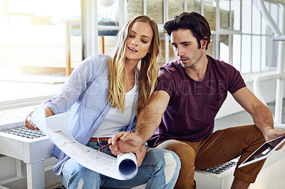 Buy stock photo Shot of a focused young couple drawing plans and choosing colors for the renovation of their house