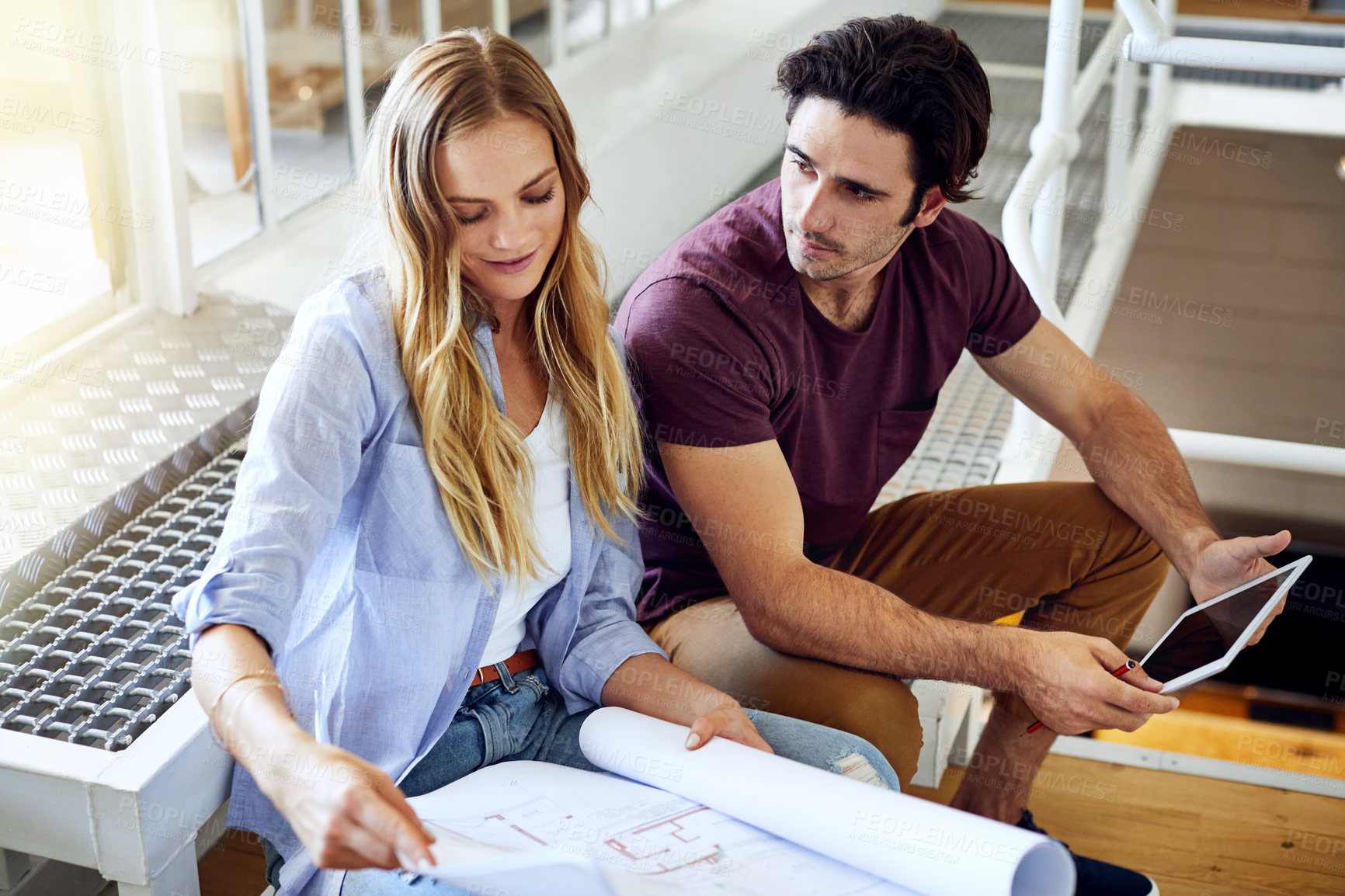 Buy stock photo Shot of a focused young couple drawing plans and choosing colors for the renovation of their house