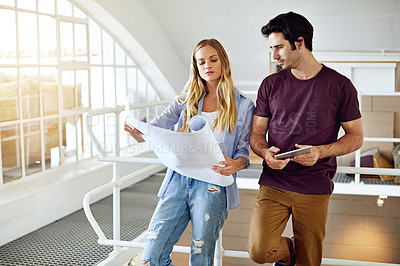 Buy stock photo Shot of a focused young couple drawing plans and choosing colors for the renovation of their house