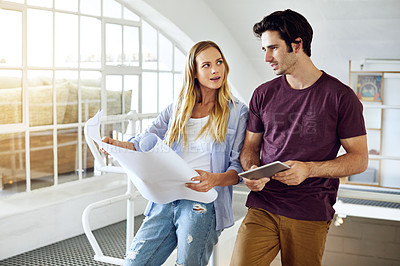 Buy stock photo Shot of a focused young couple drawing plans and choosing colors for the renovation of their house