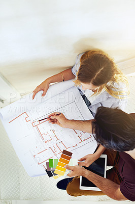 Buy stock photo High angle shot of a focused young couple drawing plans and choosing colors for the renovation of their house