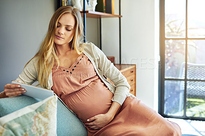 Buy stock photo Shot of a pregnant woman using a digital tablet at home
