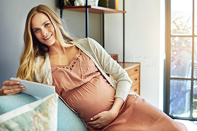 Buy stock photo Shot of a pregnant woman using a digital tablet at home