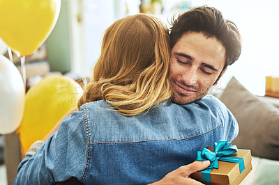 Buy stock photo Shot of a young couple exchanging gifts at home