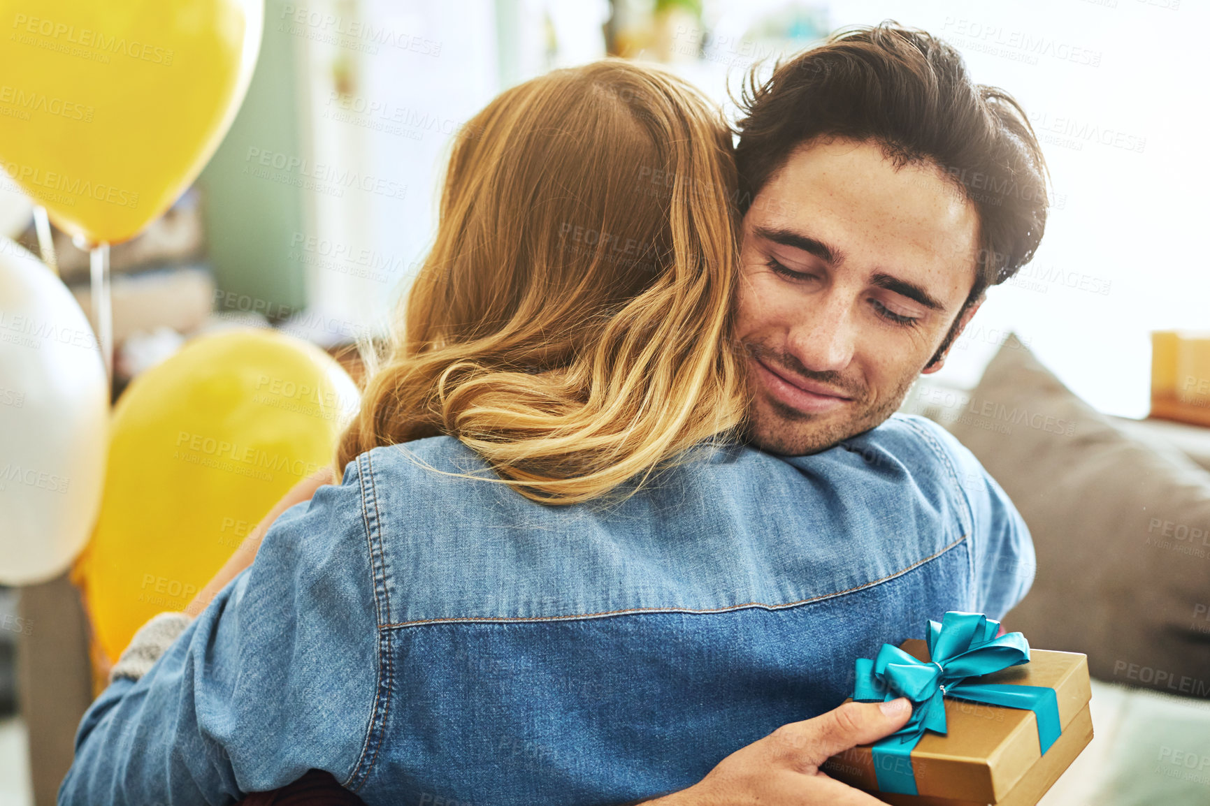 Buy stock photo Shot of a young couple exchanging gifts at home