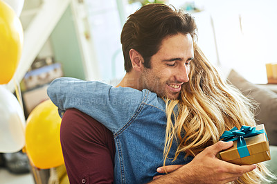 Buy stock photo Shot of a young couple exchanging gifts at home