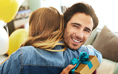 Buy stock photo Shot of a young couple exchanging gifts at home
