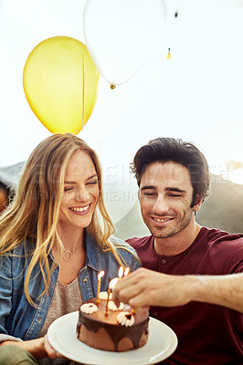 Buy stock photo Shot of a young couple having cake while celebrating a birthday at home