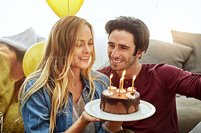 Buy stock photo Shot of a young couple having cake while celebrating a birthday at home