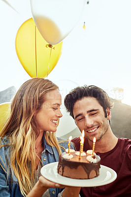 Buy stock photo Shot of a young couple having cake while celebrating a birthday at home