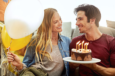 Buy stock photo Shot of a young couple having cake while celebrating a birthday at home