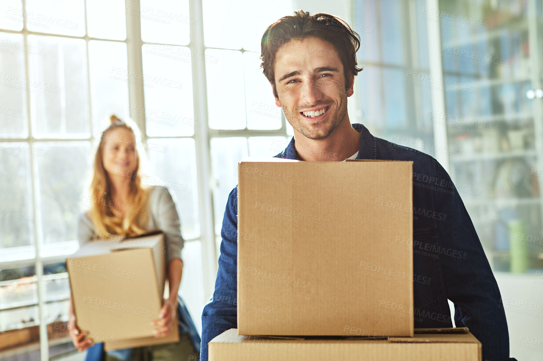 Buy stock photo Shot of a young couple moving into their new home