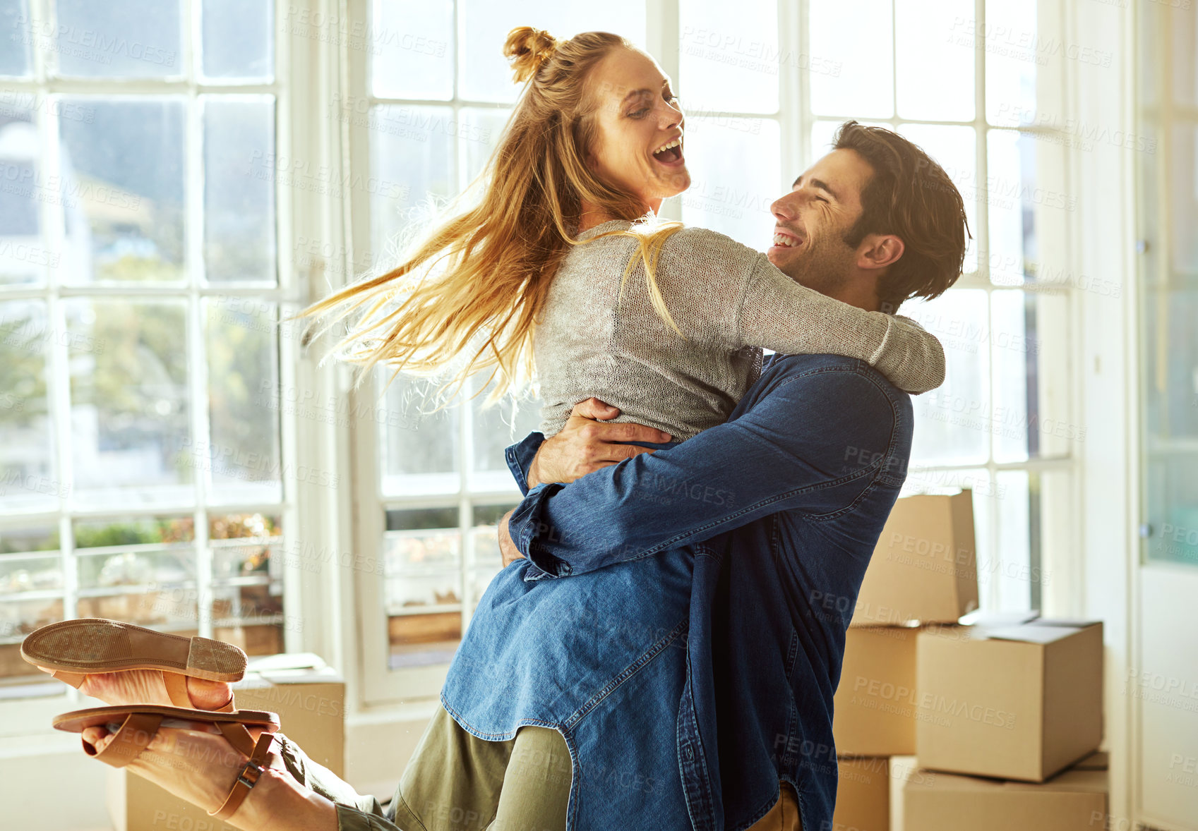 Buy stock photo Shot of an affectionate young couple moving into their new home