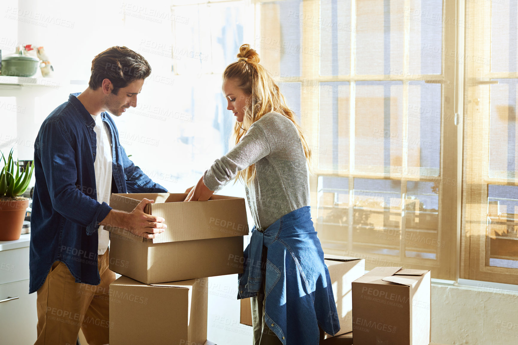Buy stock photo Shot of a young couple moving into their new home