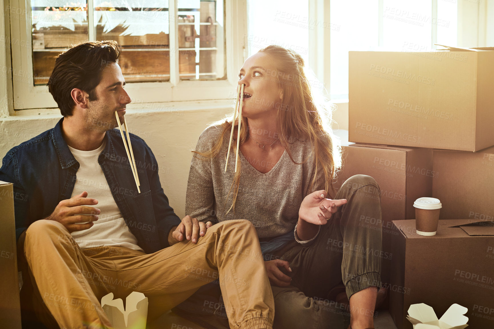 Buy stock photo Shot of a young couple eating takeout while taking a break moving into their new home