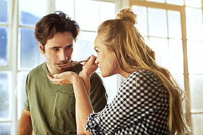 Buy stock photo Shot of a young couple preparing a meal together at home